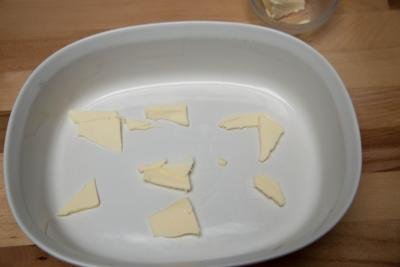 Slices of butter on the bottom of a ceramic dish