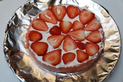 Sponge cake layered with cream and with strawberry slices on top