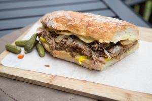 Cuban Pork Sandwich cut in half on a cutting board lined with parchment paper