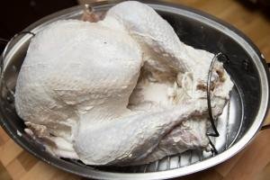 Seasoned turkey in a turkey cooker tray