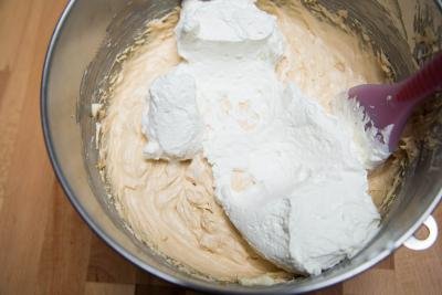 Whipping cream being folded in with butter cream with a spatula
