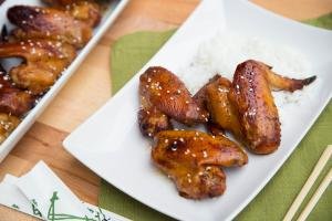 Easy Glazed Chicken Wings on rice on a plate with chopsticks next to the plate