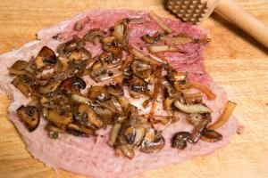 Mushroom and onion mixture spread on the pork