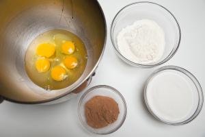 4 bowls one with 5 eggs, another with cocoa, third with flour and fourth with sugar