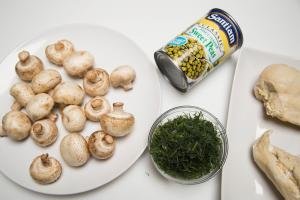 Ingredients on the table include; mushrooms, dill, peas in a can, and 2 chicken breasts