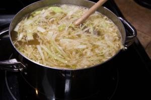 Cabbage added to boiling pot of water and meat