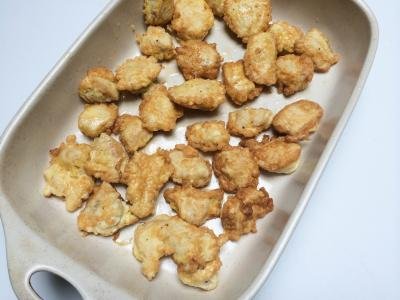 fried chicken pieces placed into a baking dish