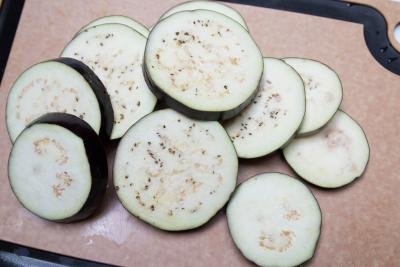 eggplant cut into 1 in width slices on a cutting board