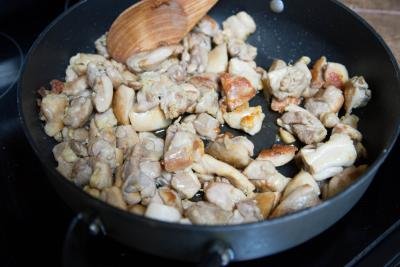 Chicken pieces being fried in a skillet