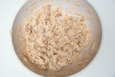 Cream cheese and pulled apart chicken mixture mixed in a bowl