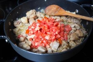 diced tomatoes added to chicken and onion mixture in the skillet