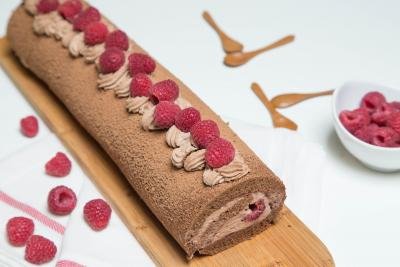 Raspberry Chocolate Roll on a long rectangular cutting board