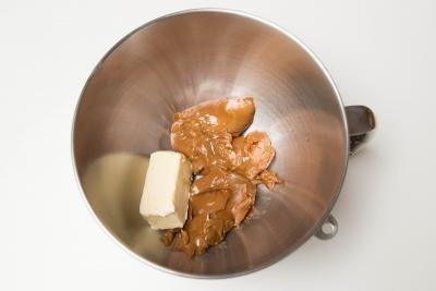 A stick of butter and dulce de leche in a large mixing bowl