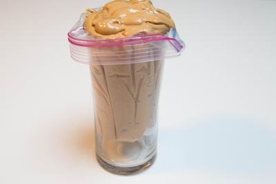 Ziploc bag placed into a cup and filled with cream