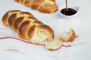 European Easter Bread on a kitchen towel with jam in a bowl besides it
