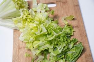 lettuce being chopped up on a cutting board