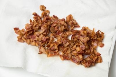 Fried bacon resting on a paper towel