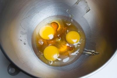Honey and 3 eggs in a mixing bowl