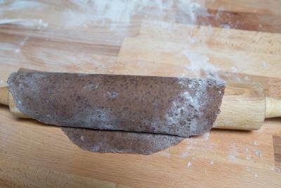 Dough being rolled out on a floured surface