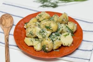 Creamy Herbed Potatoes on a plate with a wooden spoon besides it