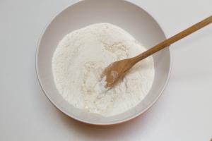 Water added to the flour mixture and combined using a wooden spoon