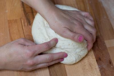 Dough being kneaded on a floured cutting board