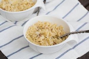 Creamy Orzo Bacon Pasta in a small bowl with a spoon in the pasta