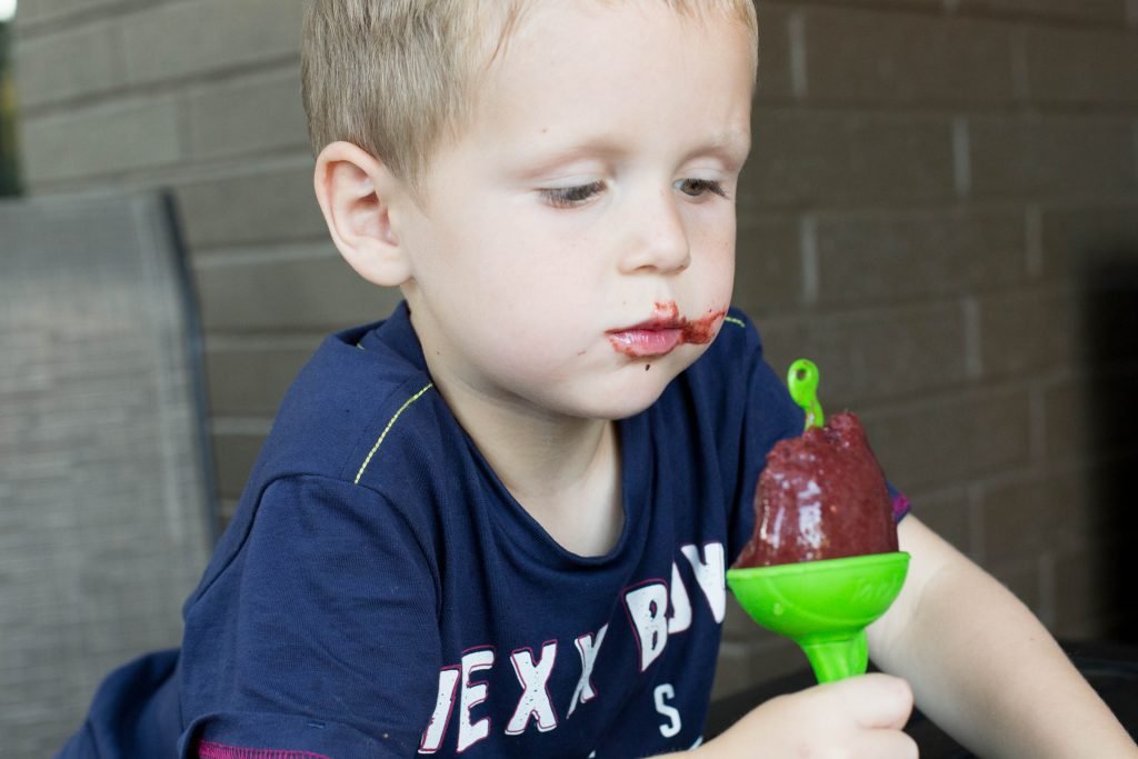A boy eating a popsicle
