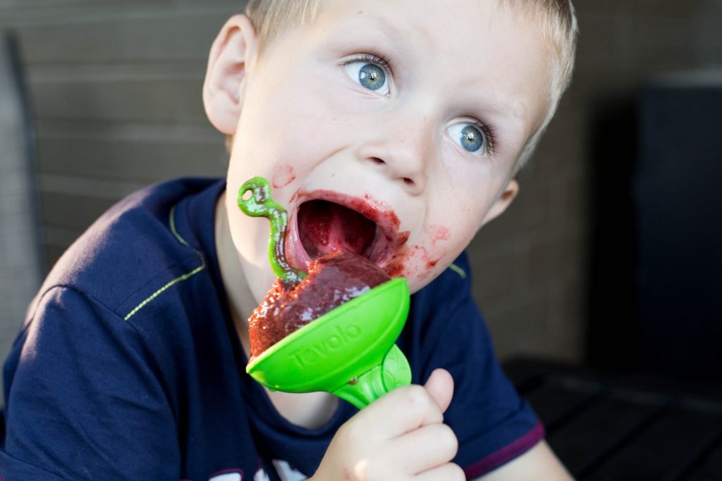 A boy eating a popsicle