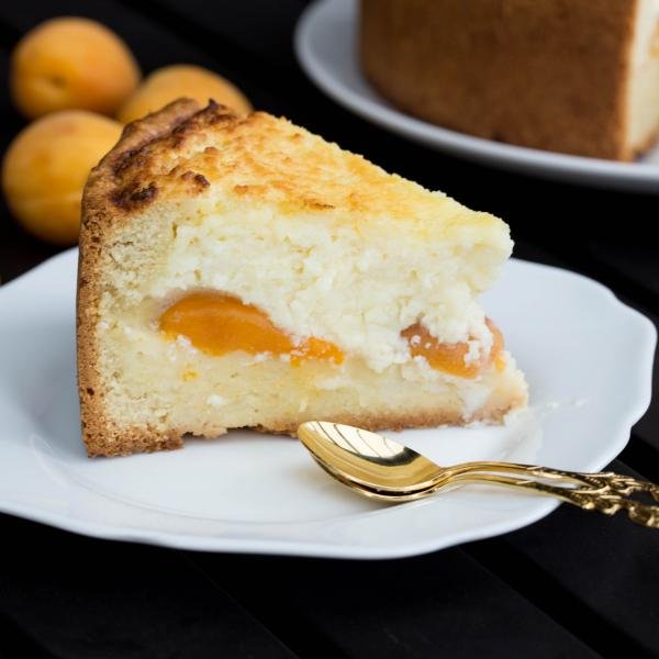 Apricot Farmer Cheese Cake slice on a plate with a spoon next to it