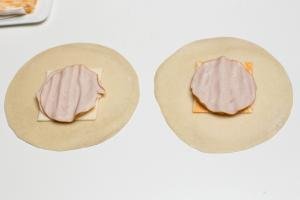 Cheese and deli meat placed in the middle of a tortilla