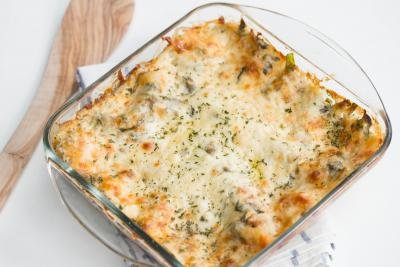 Spinach Dip Lasagna in a baking pan standing on a kitchen towel
