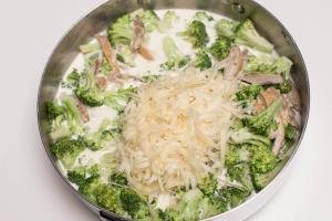 Cheese added into deep skillet with broccoli, chicken and heavy whipping cream