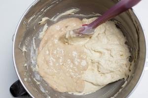 Mashed banana added into the cake batter that is in the mixing bowl