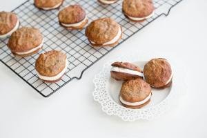 Banana Almond Whoopie Pies on a baking rack in rows and 3 on a small plate