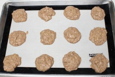 Spoonfuls of batter spread on a baking pan lined with a silicon mat