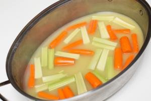 Carrots and celery in a large baking dish with the chicken bouillon