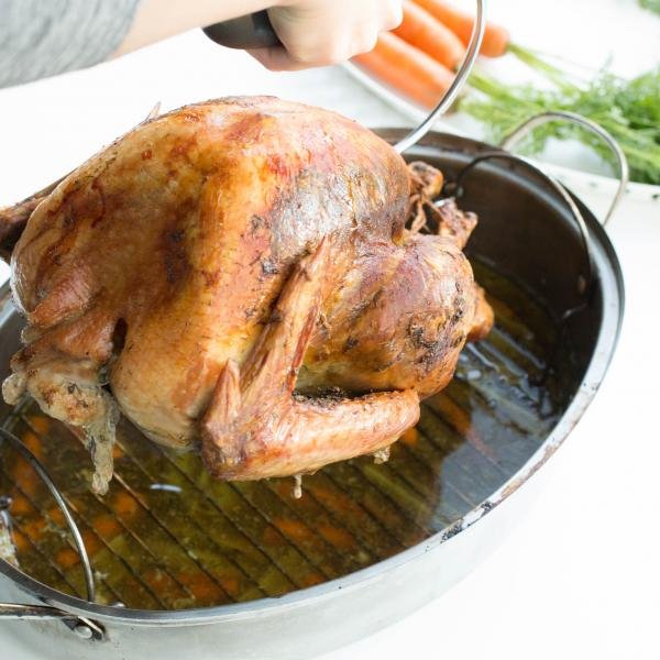 turkey being lifted off a baking pan