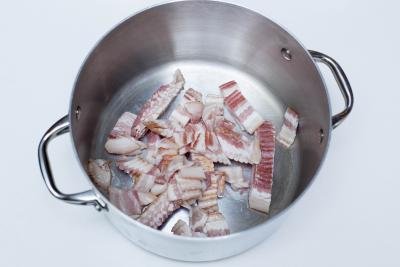 Bacon being fried in a pot