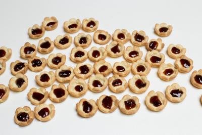 Each mini tart laid out on the table and jam placed in the middle of the tart