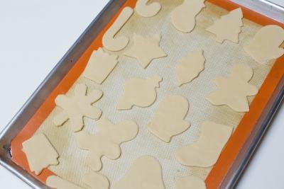 Cut out cookies placed on a baking pan lined with a silicon mat
