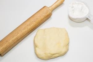 Dough, a rolling pin and flour on the table