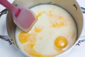 Egg yolks, water and condensed milk in a saucepan