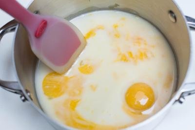 Egg yolks, water and condensed milk in a saucepan