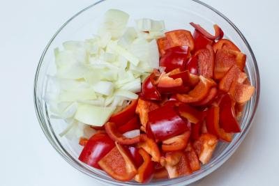 Cut up onions and red bell peppers in a bowl