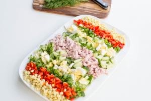 Russian Cobb Salad with ingredients layer out in rows and not mixed together\
