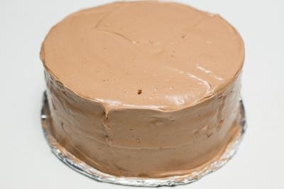 Cream spread on the top and sides of the cake