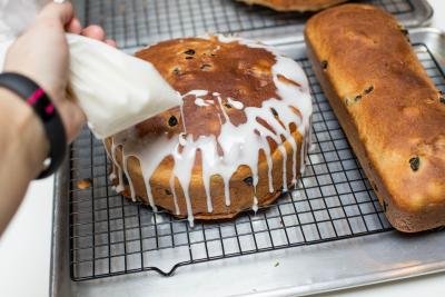 A ziploc bag being used to pour glaze over the top of the Easter Bread