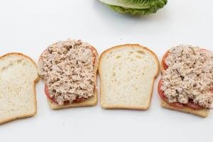 4 slices of bread, 2 with tomatoes, onions and the tuna mixture on them and 2 with nothing on them