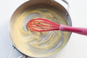 Butter and flour being whisked together in a deep skillet
